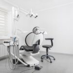 An empty dental chair with examination equipment in a bright clinic