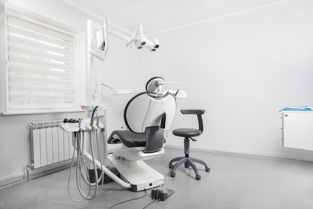 An empty dental chair with examination equipment in a bright clinic